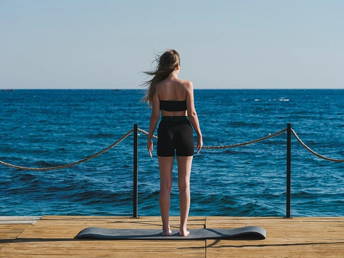 Femme face à la mer en méditation — moment de filtration intérieure